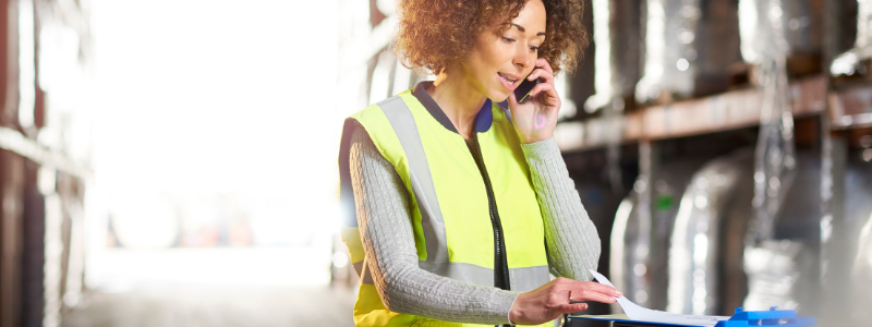 Woman Wearing a Safety Vest and on a Phone