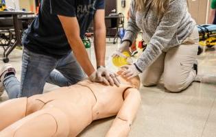 Two People Performing CPR on a Manikin