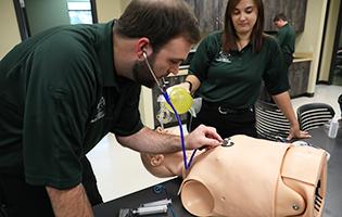 Male and female EMT students learning